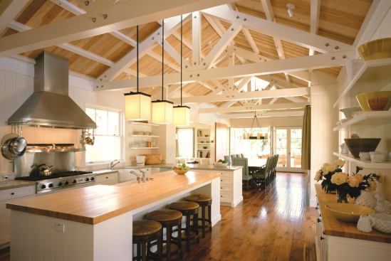 The interior applies vernacular elements—timber trusses, fir ceilings, and hickory floors—to a livable open floor plan.