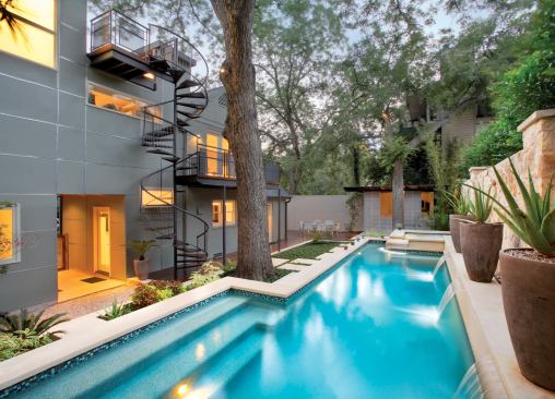 The remodel of this Austin home includes a series of decks that add to its outdoor spaces. The spiral staircase connects the decks to the yard and shadows the form of the site's towering pecan trees.