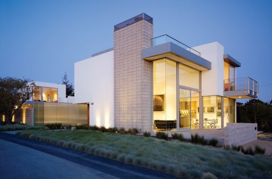 The main house and guest quarters face each other across a courtyard enclosed by a garden wall of concrete block and cast glass.