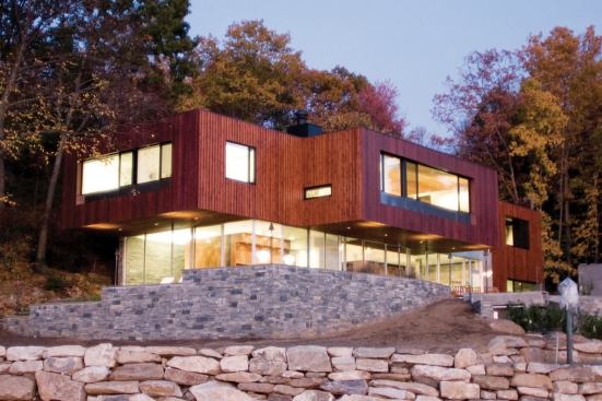 A glass curtain wall at the ground floor heightens the drama of the deeply cantilevered structure above.