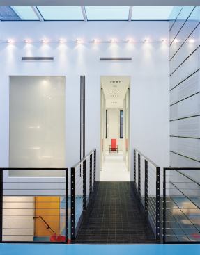 A steel-grate bridge leads to the master bedroom suite. The etched glass panel to its left lights a large walk-in shower.