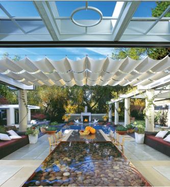 The sail-inspired sunshade is made of woven mesh fabric supported by aluminum tube battens attached to steel tension cables with boating shackles. A twist of the shackle releases the cloth for cleaning.