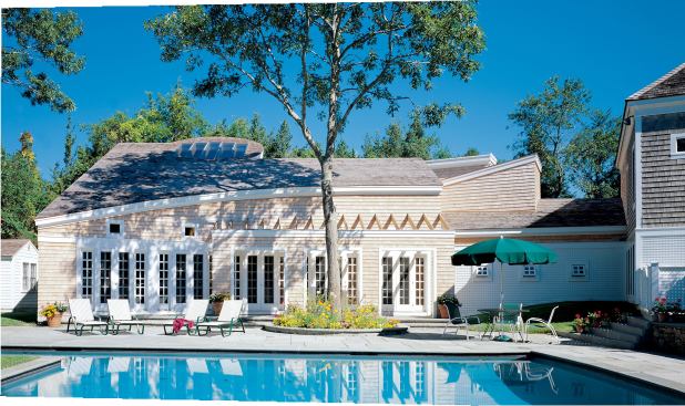 Foote employed a curve in the pool house fa&ccedil;ade to imply enclosure and focus attention to the terrace and pool area. He says,“The curve stops the eye as you look down from the main house to the pool.” Although the shape is a departure from the local vernacular, its white cedar shingle siding ties it to surrounding buildings.