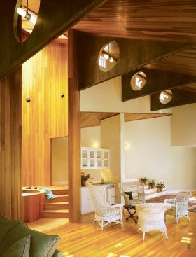 A circular cut-out in the middle of each of the intricate ceiling trusses contains a waterproof light fixture.“They give a rhythm to the room,” says architect Steven Foote of the laminated birch trusses.