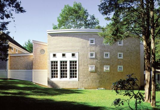 The rear fa&ccedil;ade of the pool house faces the closest neighboring home, so Foote used a tic-tac-toe fenestration that would let light into the dressing rooms and shower without giving away too much to the neighbors.