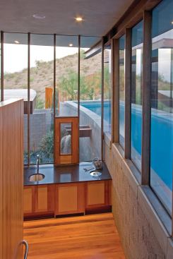 A coffee bar on the stair landing overlooks a sluice that fills a lower-garden spa.