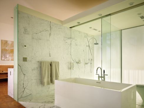 A marble-lined, etched glass box houses cleverly fitted bath, shower, and toilet spaces—plus a walk-through closet—while buffering the master bedroom suite from the public area of the house.