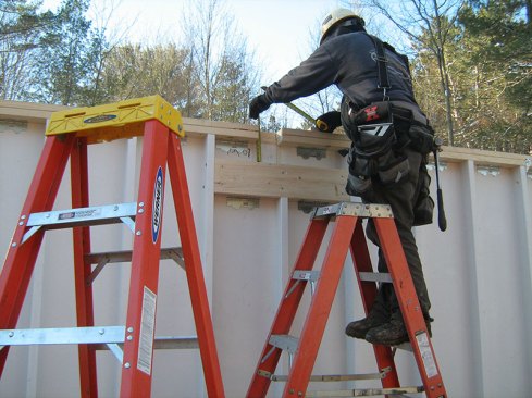 A worker connects two panels.