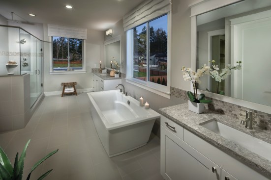 The homes at Quadrant's Copperwood in Renton, Washington include large baths with both a free-standing tub and a large shower with a rain showerhead.