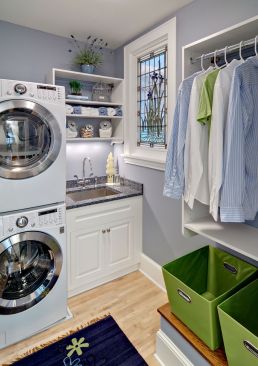 Despite its small footprint, this LEED-certified laundry room by Mary Maney of Crystal Kitchen+Bath Design Build features stacked equipment and a sink that the homeowner also uses to rinse his tools after a session in the adjacent art studio. To allow more natural light into the space, a stained glass window that was repurposed for the century-old home's bathroom looks out over a stairwell that is illuminated by a skylight.