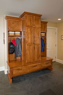 A good portion of Crystal Kitchen + Bath's clientele includes active families, and its reflective in projects like this, a back entry utility room that includes a custom wood cabinet and bench with hooks for coats and ample space for sporting equipment. 