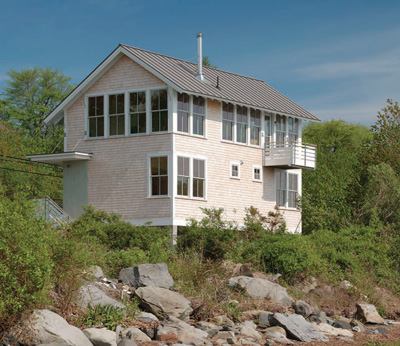 With its simple shape and clever economy, this 1,440-square-foot waterfront house updates the classic fishing shack. Its poetic logic is a response to coastal zoning requirements, which placed it close to the street and lifted it 6 feet above the ground.