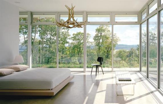 Perched at the edge of a steep slope, this weekend home arrays its primary living spaces both indoor and outdoor to capture the view.