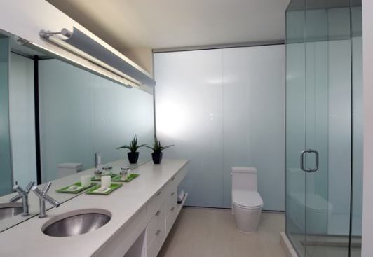 Natural light enters the master bathroom several ways -- through laminated glass panels sandwiched over white film, through a skylight above the shower, which is also lit electronically from the outside, and through tall narrow windows.