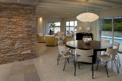 The design of the dining room light fixture imitates the rhythm of the ceiling detail and helps define the seating area.