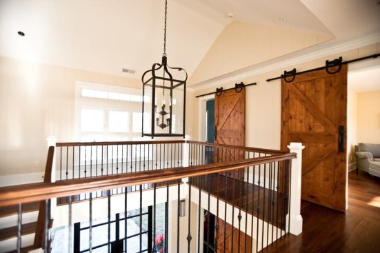 Mounted on wrought-iron slides and rails, the house's custom pine barn doors are one of the special details tying the design closer to its inspiration. The wide, zero-threshold openings also are an accessibility feature.