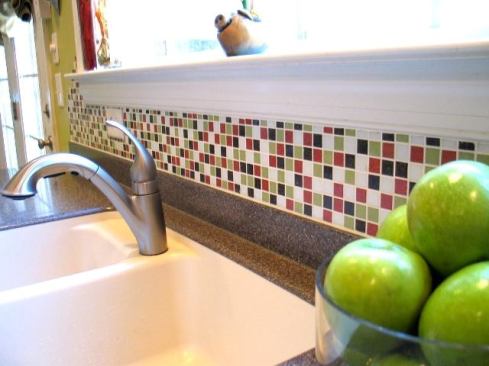 Want a culinary space that feels festive? Try some confetti on for size. The owner of this light-filled kitchen went with Modwalls Brio 3/4-inch vitreous glass tiles to unify a design inspired by the colors of caramel apples. “I took cues from around the room: Pear to match the bright green walls, Terra Cotta to play off the orange tones in the cabinetry, Walnut to pick up the countertops, and Soft White to keep it all bright and airy,” she explains. “It’s fun, crisp, and happy!” Using equal parts of each hue, she used Modwalls’ online blender tool to create a scattered design that’s balanced but not uniform: 
http://www.modwallsblender.com/blender.html