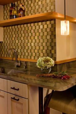 This remodeled condo by Texas Construction Co. in downtown Austin has amazing skyline views, but its kitchen and bar areas are pretty easy on the eyes, too. For the backsplashes, the design team went with a staggered checkerboard pattern of slate and glass to accent the urban home’s earthy palette and white oak trim. The 1,500-square-foot, 2-bedroom unit was renovated for a couple who were downsizing from a larger single-family home in the suburbs. The space is smaller, but the finishes are every bit as upscale as what you’d find in a larger home. 
http://www.txconstruct.com