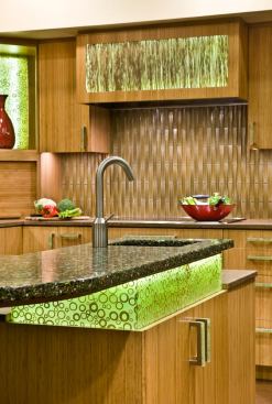 There’s nothing shy about this remodeled kitchen by TRG Architects in Burlingame, Calif. It’s sustainable in its material selections and bold in its style picks. The textured backsplash is an iridescent silica product by Oceanside Glasstile in an amber tone that matches the Plyboo cabinets. Interior designer Leslie Lamarre punched things up even further with two types of recycled glass countertops and 3Form Varia Ecoresin translucent cabinet panels. 
www.trgarch.com