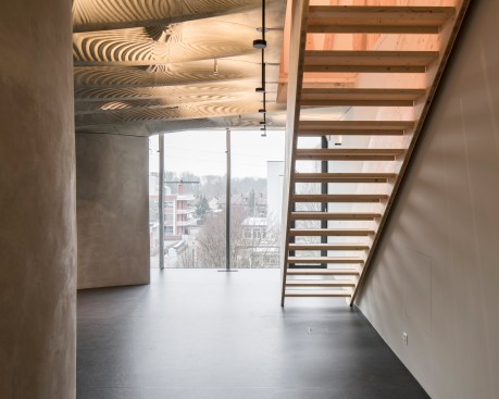 Digitally designed and prefabricated concrete mullions line the façade and help support the concrete "Smart Slab" of DFAB House in Dübendorf, Switzerland, by ETH Zurich.