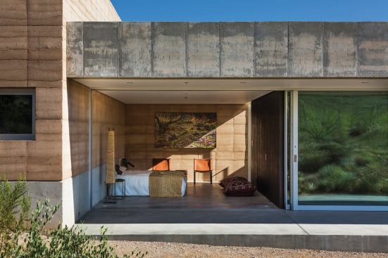 Rammed earth and concrete stem walls continue on the interior.