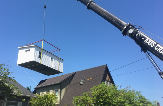 Construction crews crane a Dweller ADU into place in Portland, Ore.