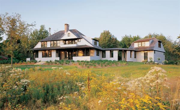 Traditional massing and materials reflect a historical lineage, but Modernist detailing signals that this cottage is no replica.