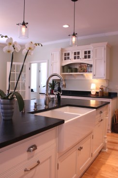 This farmhouse had received several updates and renova-
tions over the years. However, the floor plan was conflict-
ing amongst the kitchen, laundry, mudroom, and powder 
room. A complete reorganization of the first floor was 
achieved through multiple structural changes that al-
lowed for a larger kitchen and created better flow be-
tween adjacent rooms. The kitchen includes custom 
painted cabinetry, a farmhouse style sink, and soapstone 
countertops. A commercial size Viking range, hood, and 
Sub Zero refrigerator bring a theme of stainless steel to 
the kitchen which is accentuated by brushed nickel hard-
ware and island faucet. Specialty lighting, glass door 
cabinets, and a grand, eight foot island are just a few of 
the features that make this kitchen stunning.