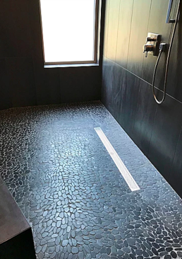 Pebble tile provides texture for the master shower floor with its linear drain.