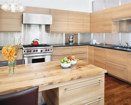Quartersawn red elm cabinets contrast with the rooms cooler elements white walls, glass panels, and stainless steel appliances and hardware.