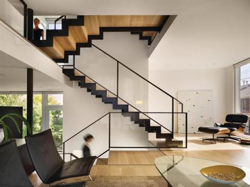 A blackened steel stair frame stitches the levels together, as do the oiled steel handrails and pickled white oak flooring.