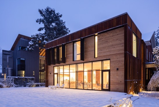 The old house's venerable brick facade still greets the street as it has for 100 years, while the view from the mid-block alleyway behind the house reveals an unexpected expanse of rust-colored steel, natural wood, and glass.