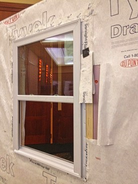 Here, a window buck and foam have been applied, the window has been installed, and then housewrap has been applied. When thick foam is used, window manufacturers may require metal jamb installation brackets to adequately support the window.