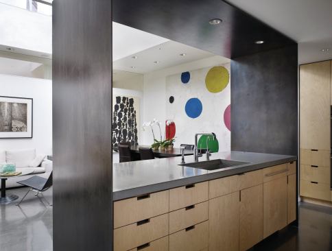 The kitchen’s blackened steel “blinders” separate it visually from the pass-through to the living area.