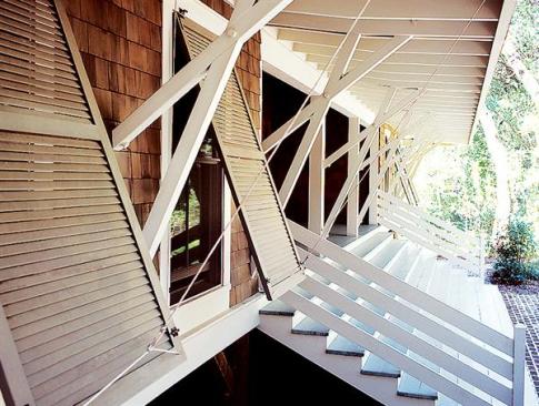 Deep overhangs and top-hinged shutters shade the building from the southern sun.