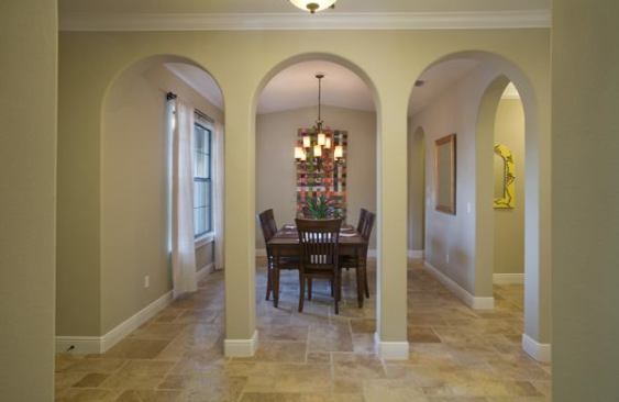 The formal dining room is part of the new addition on the front of the home. It adds square footage and helps achieve the exterior's Mission-style theme. Spray-foam insulation, insulated windows, and complact flourescent light bulbs create an energy-efficient structure. The flooring is travertine tile.