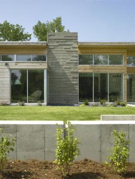 Board-formed concrete gives the chimney a masonry-like textural rhythm.