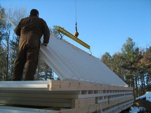 A crane is used to move them onto a truck for delivery.