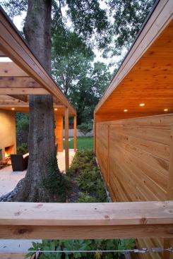 The space between the carport and living pavilion aligns with the house's 'dogtrot' center hall, creating a view corridor to the rear garden.