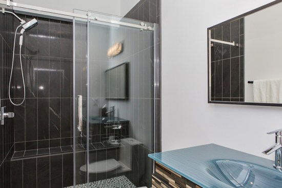 Black tile and a blue glass sink adds notes of elegance to the guest bath.