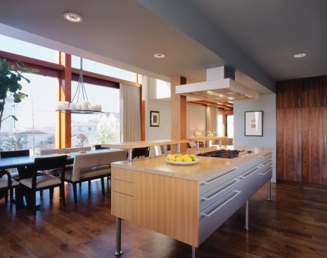 An unfussy palette of Brazilian walnut floors, vertical-grain elm cabinetry, and shell-infused granite counters lends a sense of calm to the kitchen.
