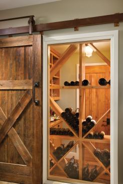 A wine closet features a glass wall with a sliding door.