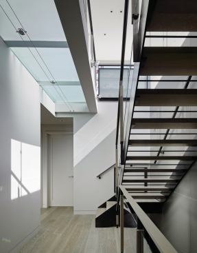 Glass flooring funnels light down through the stairwell.