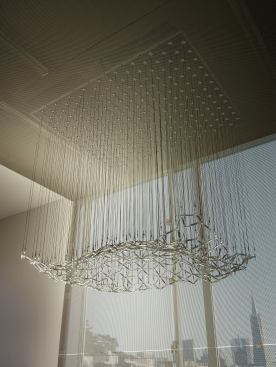 The sculpture and metal scrim have a gauzy effect in the sunlight.