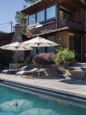 The compact swimming pool terrace includes board-formed concrete retaining walls and built-in seating.