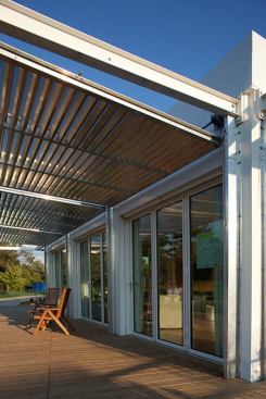 The sliding custom louvers are light and easy to move from deck shading to interior protection positions. In addition to hurricane fortifications, the panels also offer privacy or cool coverage for the translucent window walls.