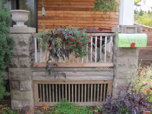 The front porch railing and screening were reclaimed from the former house’s stairs and decking, respectively.