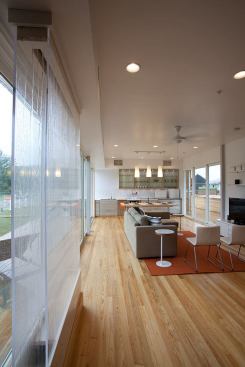 The continual glazing on the north-facing glass wall allows natural light to permeate all of the interior public spaces even when the argon-filled sliding doors are closed and further screened with interior shades during times of extreme temperatures.
