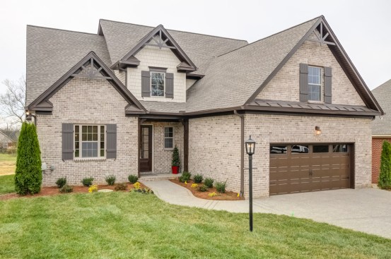 Revised
to fit the lot, the garage on the altered version faces the front of the home. Brick
covers nearly the whole exterior (Jenkins notes the material’s popularity in
Nashville, which he says is due to its low-maintenance appeal for resale).
Decorative trusses are a detail that feels current.Photo courtesy of Frank Batson Homes.