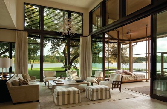 Sliding glass walls, steel louvers, and limestone flooring blur the lines between the living room and porch. 